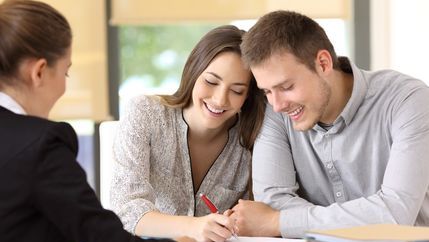 Happy couple signing  a contract