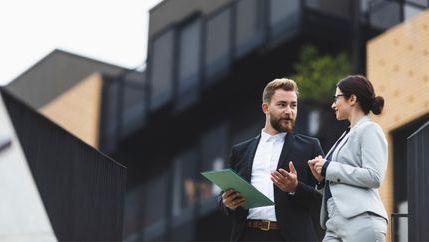 Smartly dressed colleagues talking outside